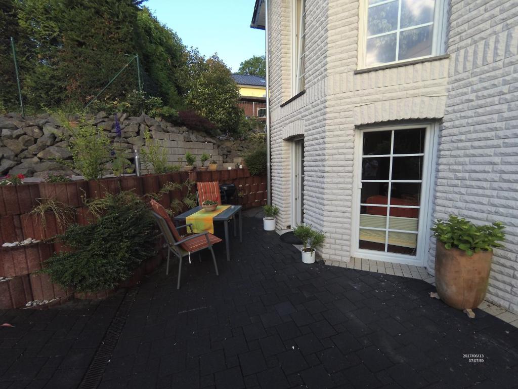a patio with a table and chairs next to a house at Büchling FEWO in Königswinter