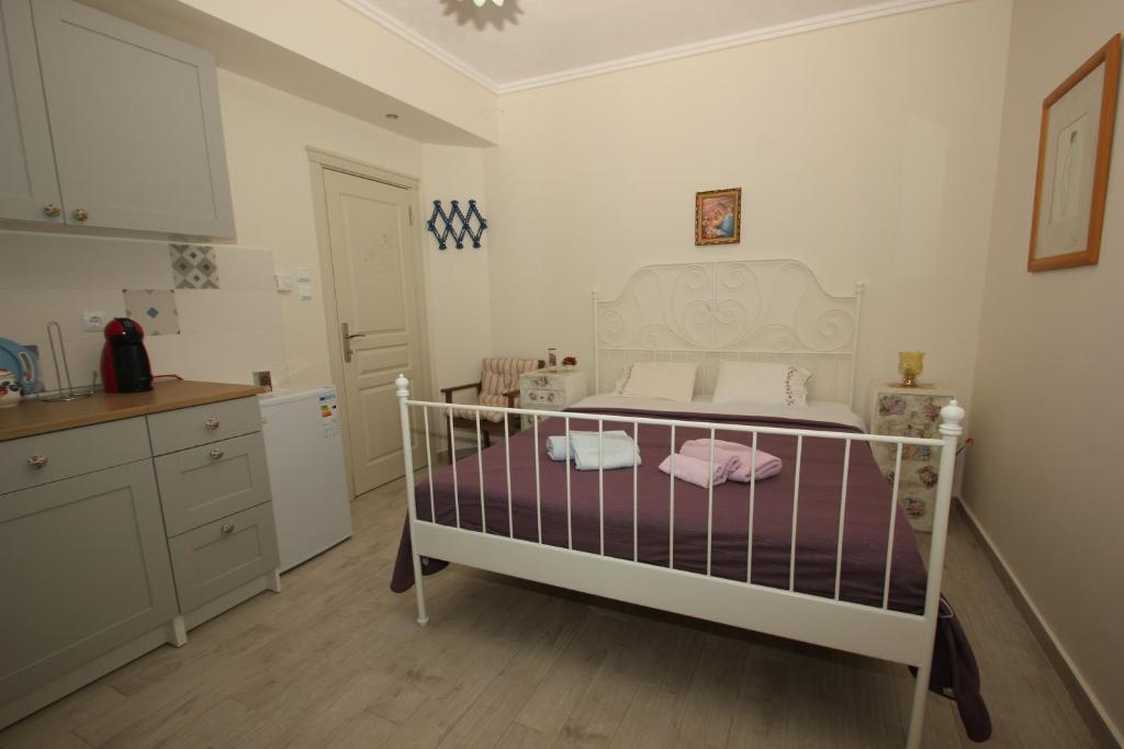 sypialnia z łóżkiem z fioletowo-białą pościelą w obiekcie Angels Home w mieście Platanitis Rodopis