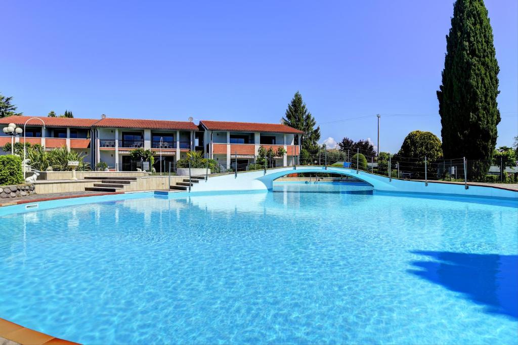 une grande piscine en face d'un bâtiment dans l'établissement Italsol Residence Riai, à Moniga del Garda