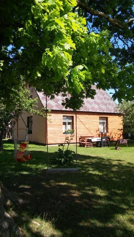 a house with a hammock in front of a yard at Searooms in Lapmežciems