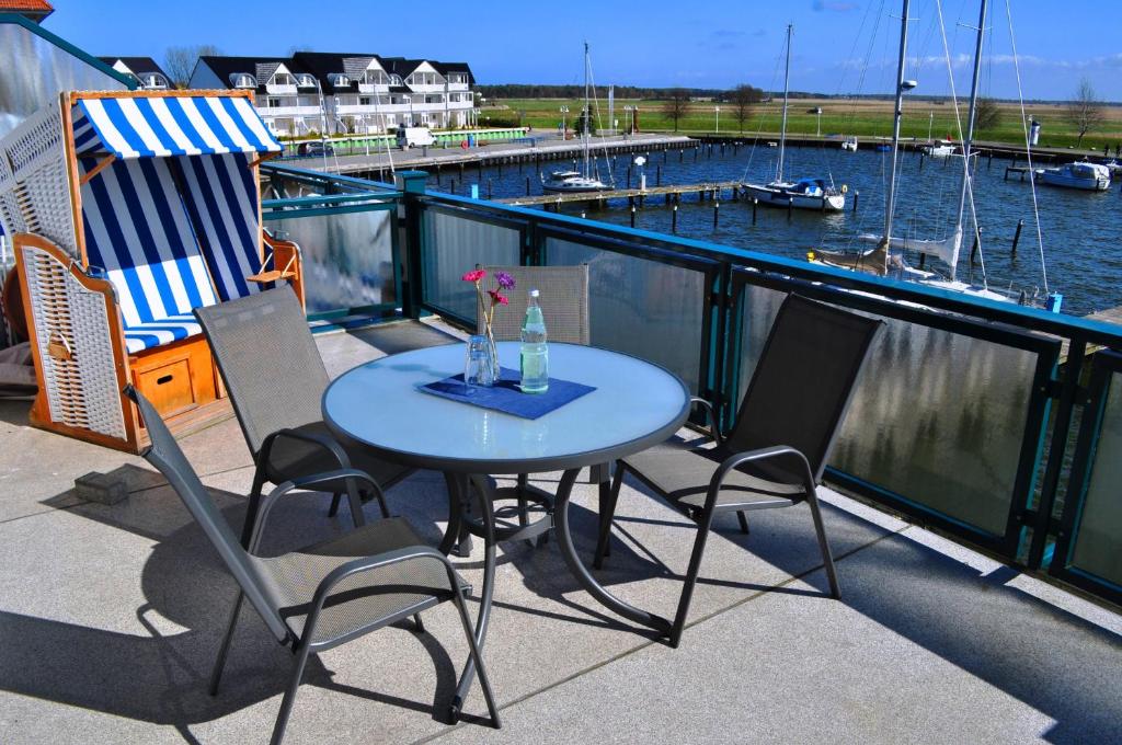 オストゼーバート・カールスハーゲンにあるFewo Sonnensegler Usedom direkt am Yachthafen mit Terrasse Parkplatz WLANのマリーナを見渡すバルコニー(テーブル、椅子付)