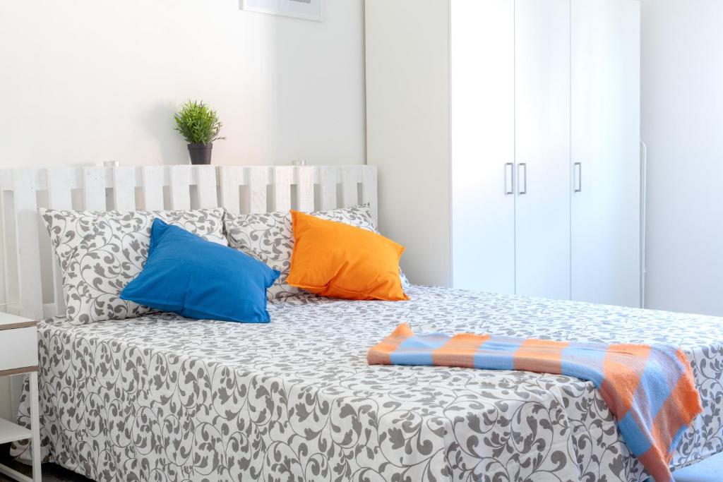リミニにあるPonte Tiberio Apartmentのカラフルな枕が付いたベッド1台が備わる客室です。