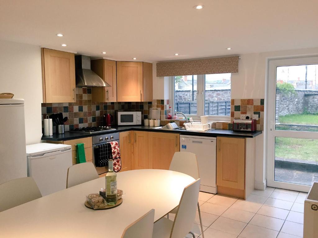 a kitchen with a table and a table and chairs at March Cottage Brecon in Brecon