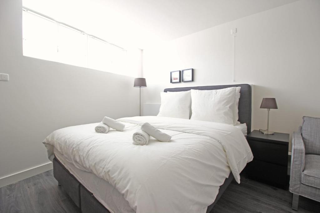 a bedroom with a white bed with two pillows on it at Guesthouse Prinsencanal 2 in Amsterdam