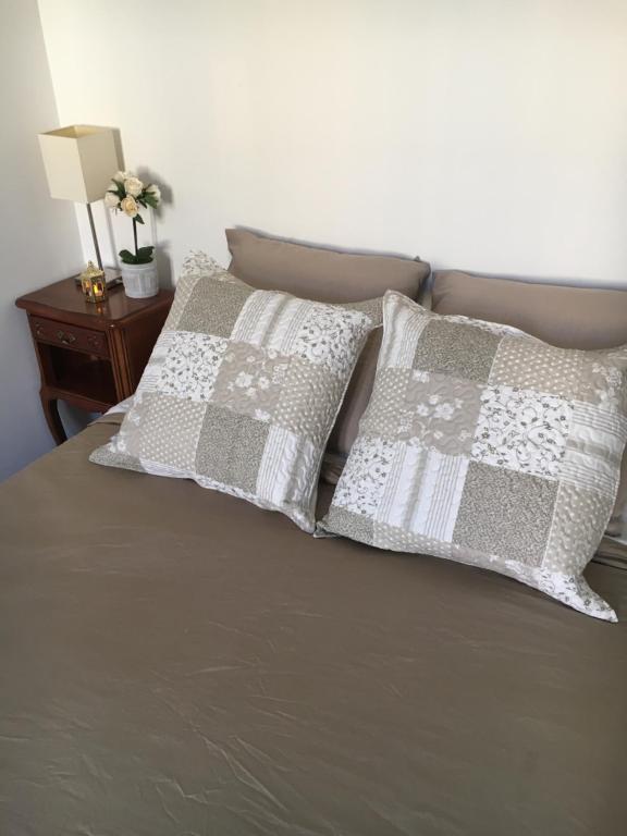 a bed with two pillows on top of it at Appartment Le Charme du Bourgeois in Nice
