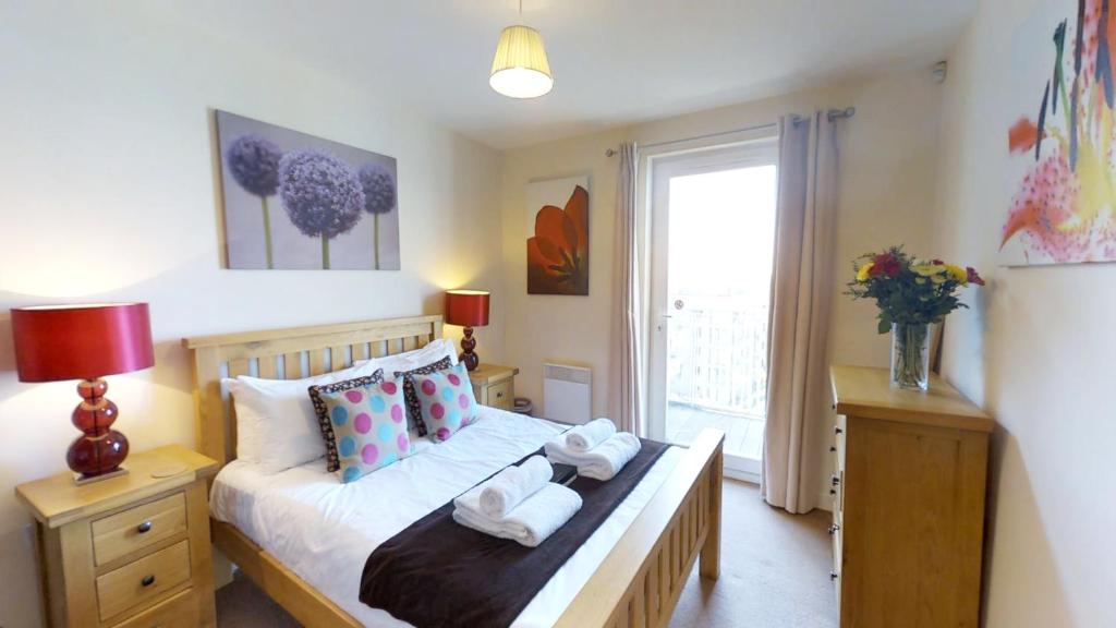 1 dormitorio con 1 cama con toallas en Signet Apartments - The Triangle, en Cambridge