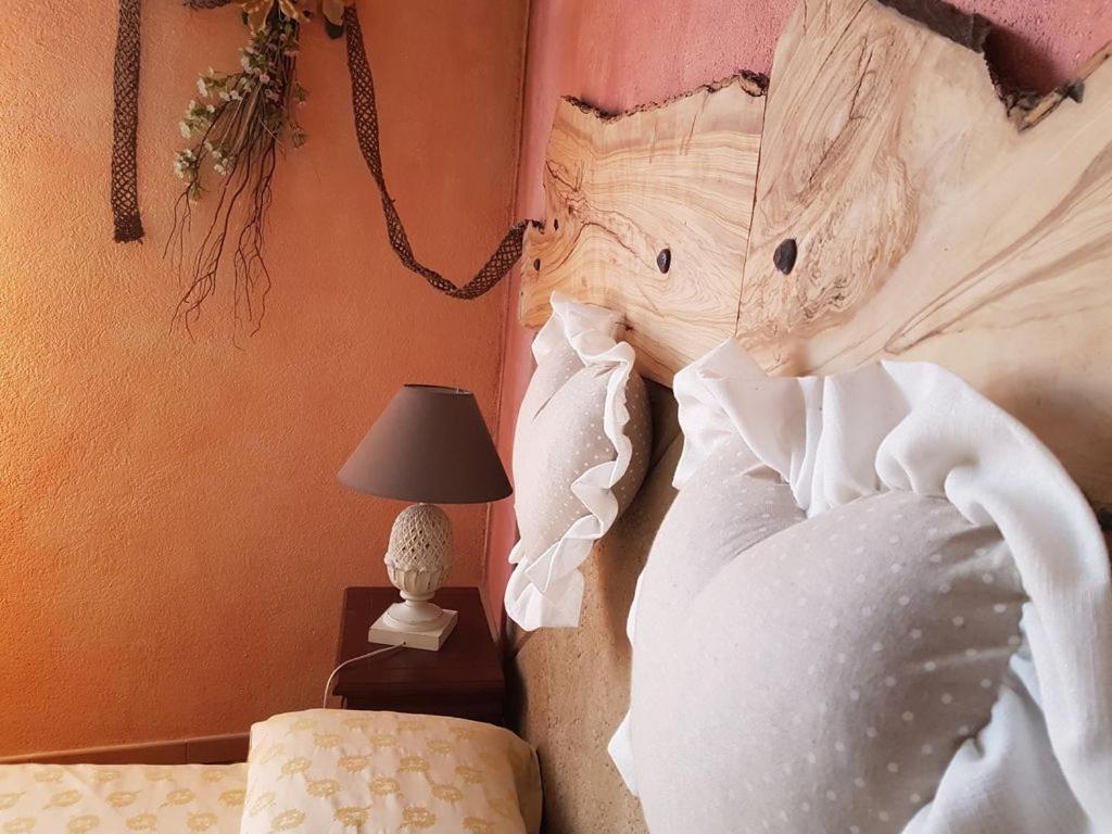 - une chambre avec un lit et une tête de lit en bois dans l'établissement Agriturismo Dinoabbo Apt, à Lucinasco