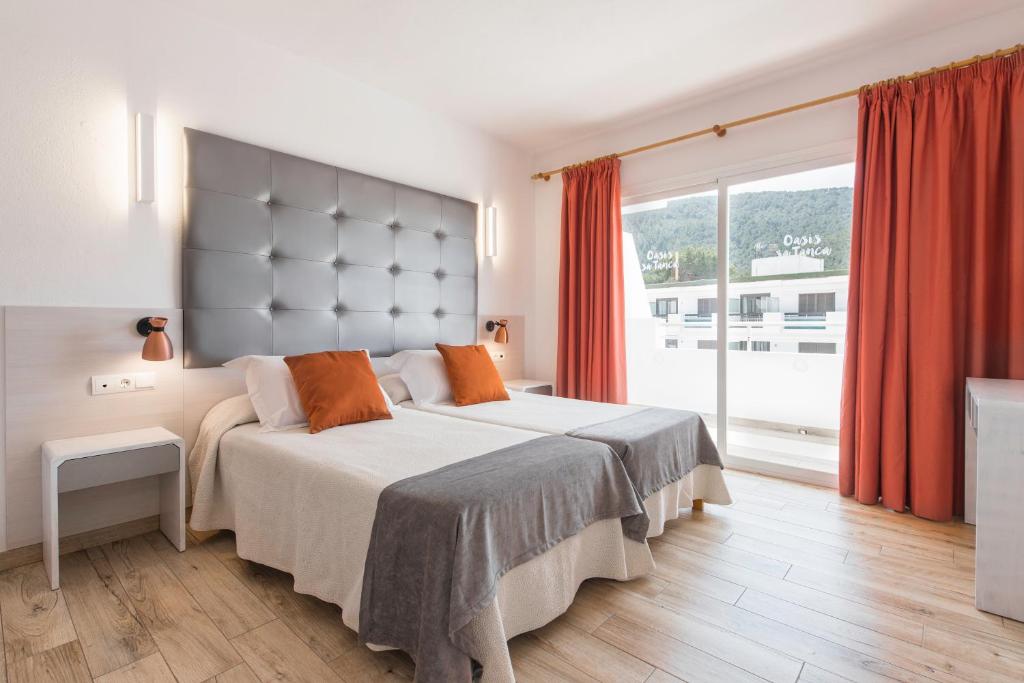 Un dormitorio con una cama grande y una ventana grande. en Typic Oasis Sa Tanca, en Cala Llonga