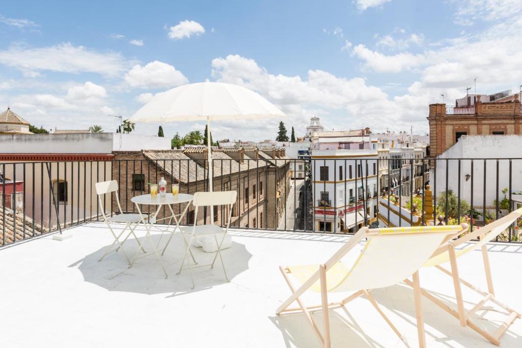 eine Terrasse mit einem Tisch und Stühlen auf dem Dach in der Unterkunft thesuites Sevilla in Sevilla