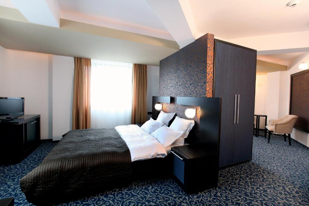 a hotel room with a bed and a television at Ambiance Hotel in Bucharest