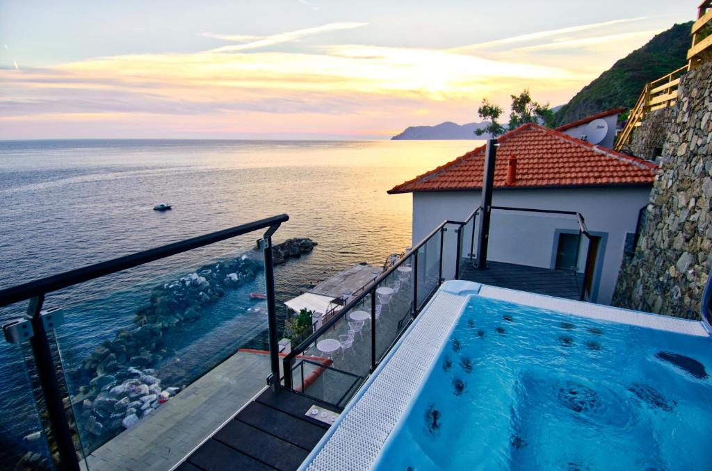 a swimming pool on a balcony next to the ocean at Crêuza de Mä in Riomaggiore