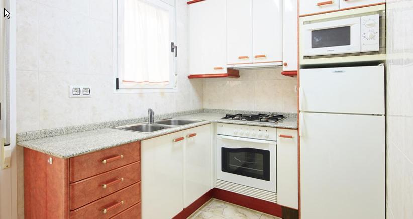 バルデロブレスにあるApartamentos Querolの小さなキッチン(白い家電製品、シンク付)