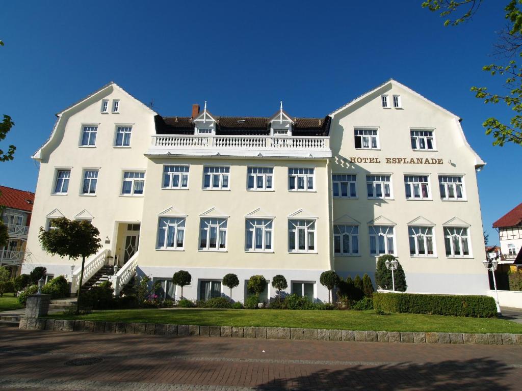 a large white building on a street at Hotel Esplanade Garni in Kühlungsborn