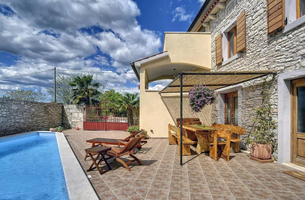 une terrasse avec une table et des chaises à côté d'une maison dans l'établissement Villa Dea, à Svetvinčenat