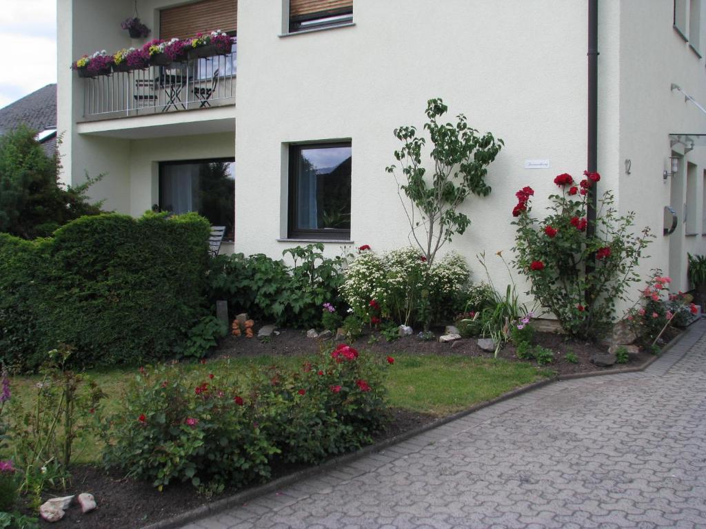 ein Garten vor einem Haus mit Blumen in der Unterkunft Ferienwohnung Arnold in Koblenz