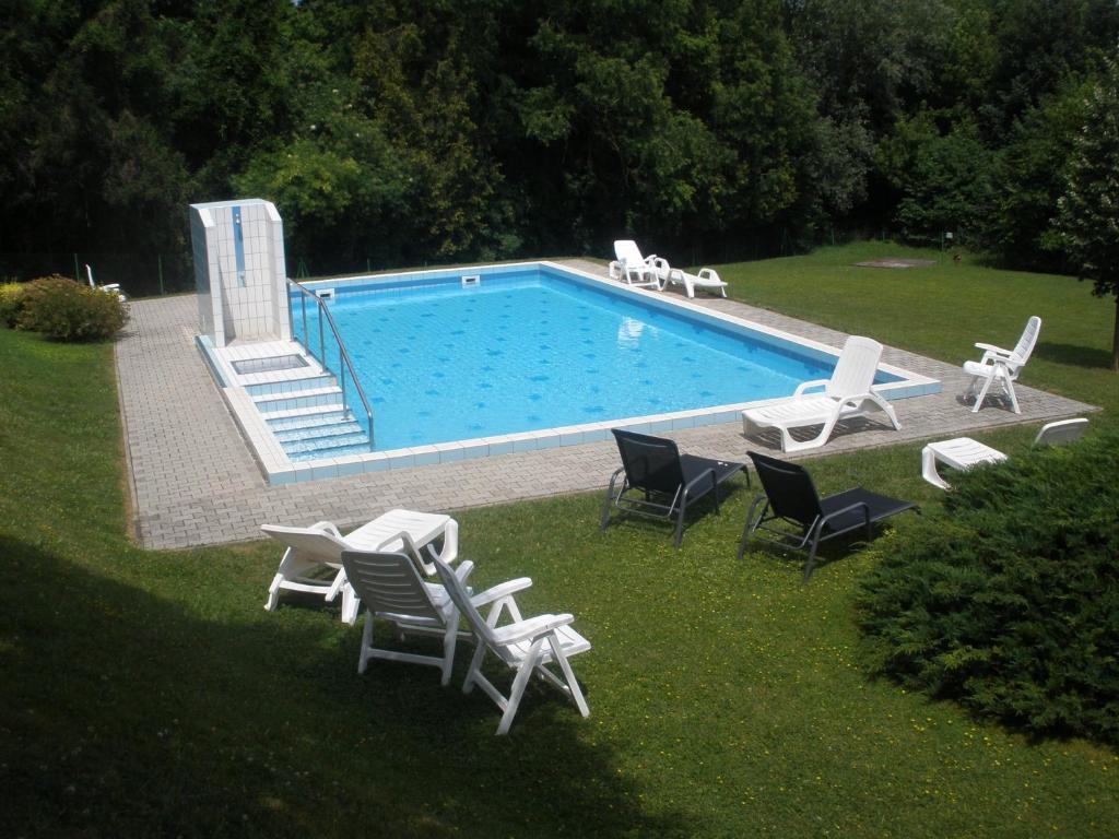 einen Pool mit Liegen und Stühlen im Hof in der Unterkunft Római Therme Apartman in Hévíz