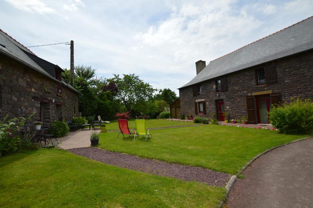 a house with a yard with chairs and a building at Chambres d'hôtes La Fontaine Garel in Iffendic