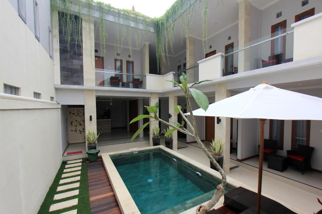 a swimming pool in the middle of a building at Tom Guest House in Legian