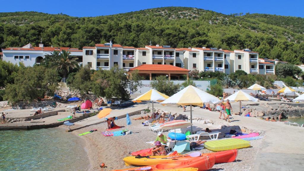 a group of people on a beach with buildings at Hotel Priscapac Resort & Apartments in Prizba