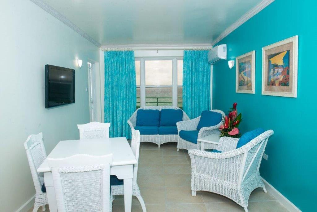 a living room with blue walls and a table and chairs at Rostrevor Hotel in Christ Church