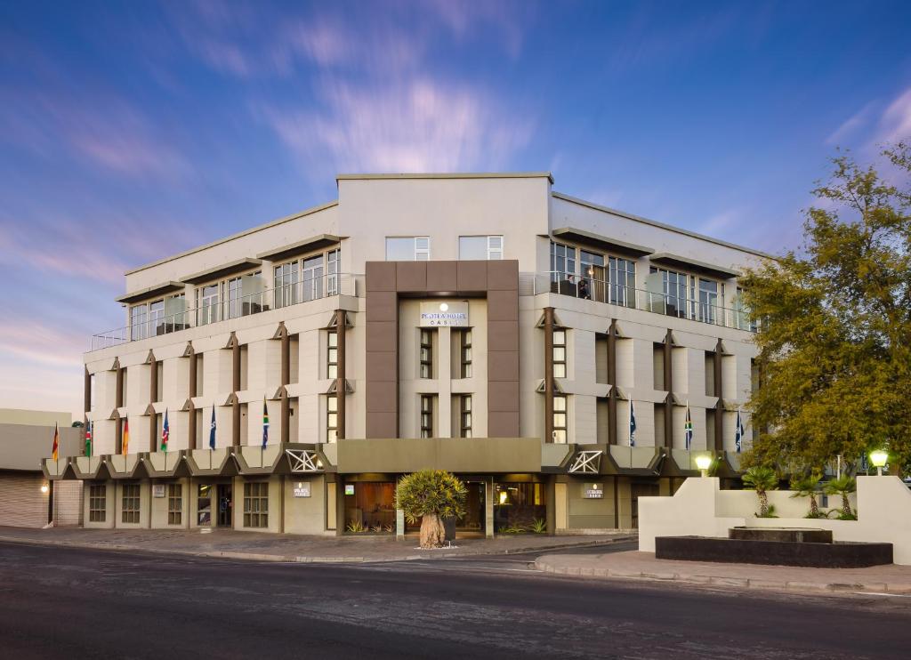 un grande edificio bianco sul lato di una strada di The Oasis a Upington