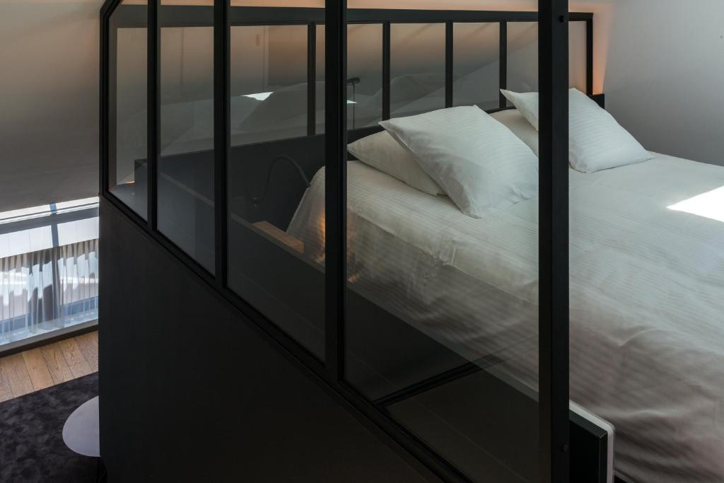 a bedroom with a bed with a glass wall at Le Florentin in Florenville