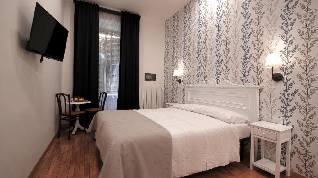 1 dormitorio con 1 cama, TV y ventana en Domus Iuliae en Roma