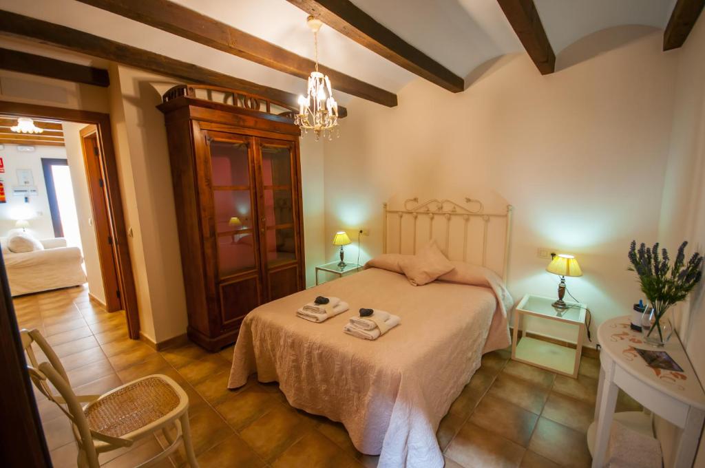 um quarto com uma cama, uma mesa e cadeiras em Apartamentos Turísticos Rincón de la Magdalena em Plasencia