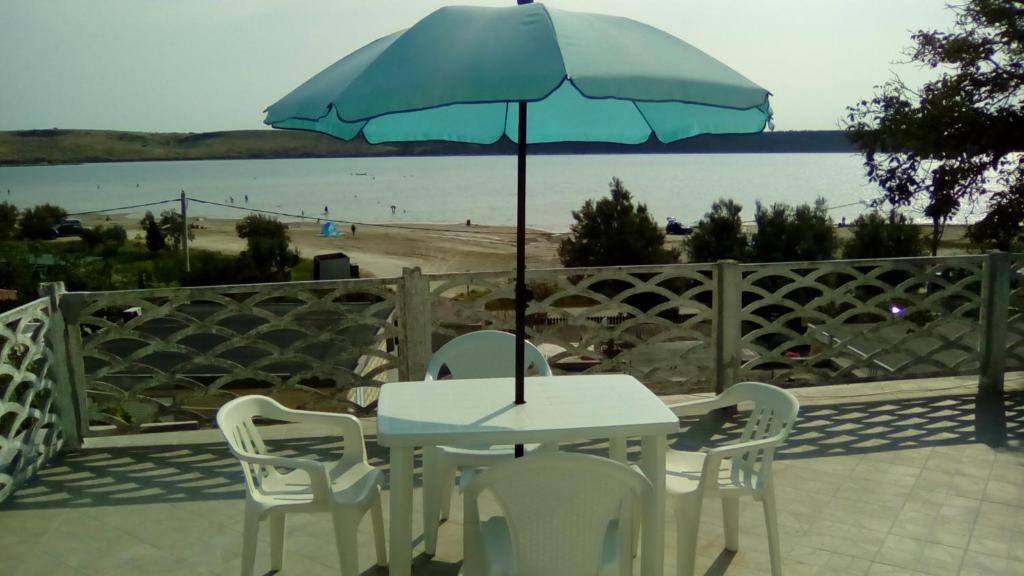 einen Tisch und Stühle mit Sonnenschirm auf einer Terrasse in der Unterkunft Apartments Mirana in Ljubač