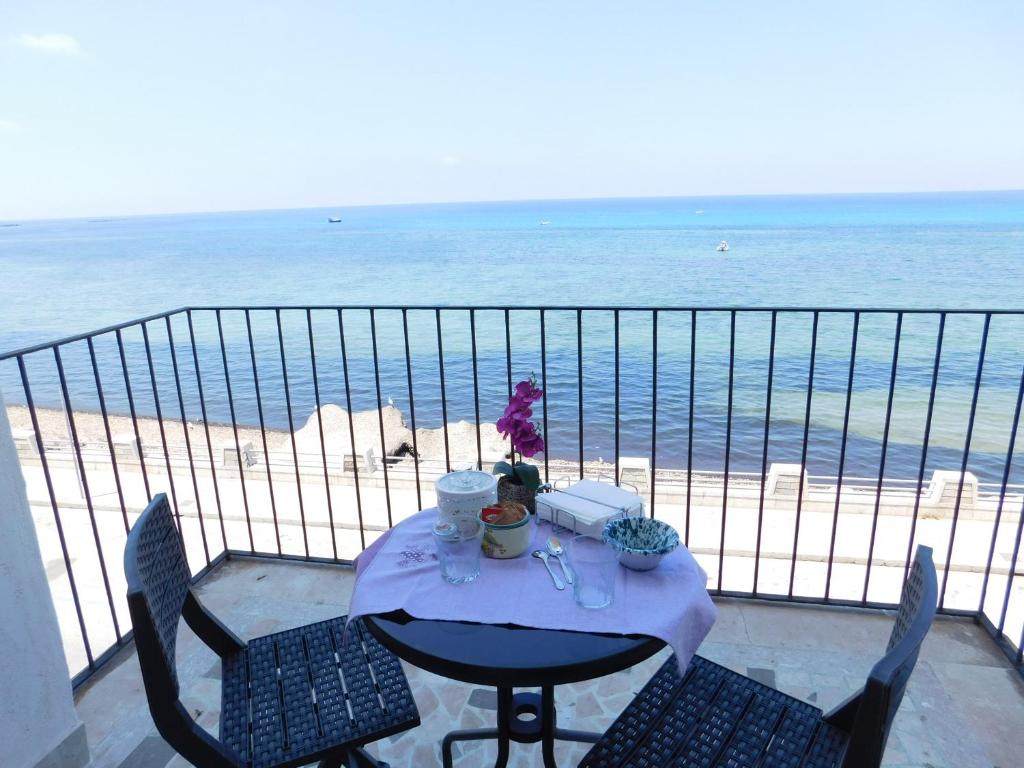 una mesa en un balcón con vistas a la playa en Appartamento Belvedere, en Trapani