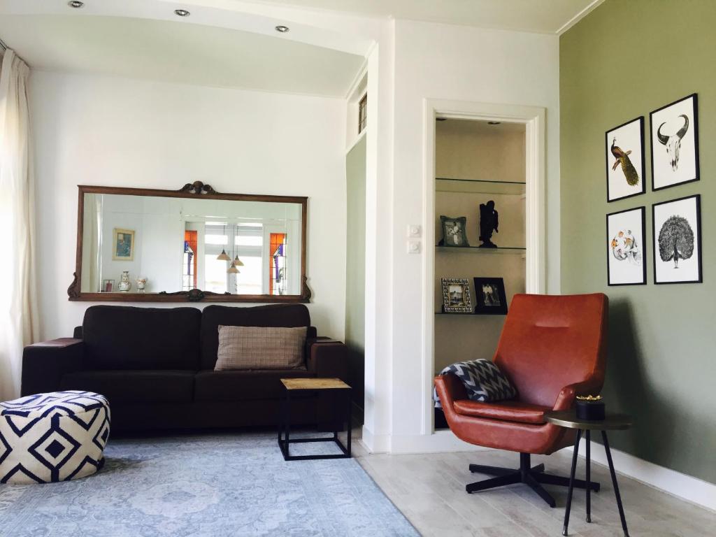 uma sala de estar com um sofá e uma cadeira em Tastefull double story 2 bedroom appartment/house em Haarlem