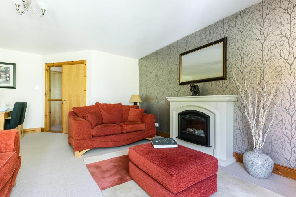 a living room with a red chair and a fireplace at Titanic View Luxury Apartment Belfast in Belfast