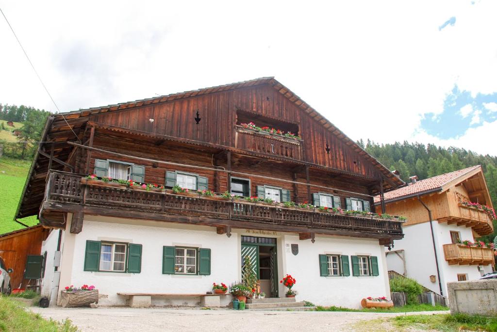 una gran casa de madera con flores en el balcón en Villgraterhof en Sesto