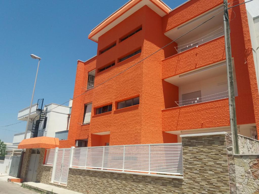 un edificio de ladrillo naranja con una valla blanca en Monolocali Angelica, en Porto Cesareo