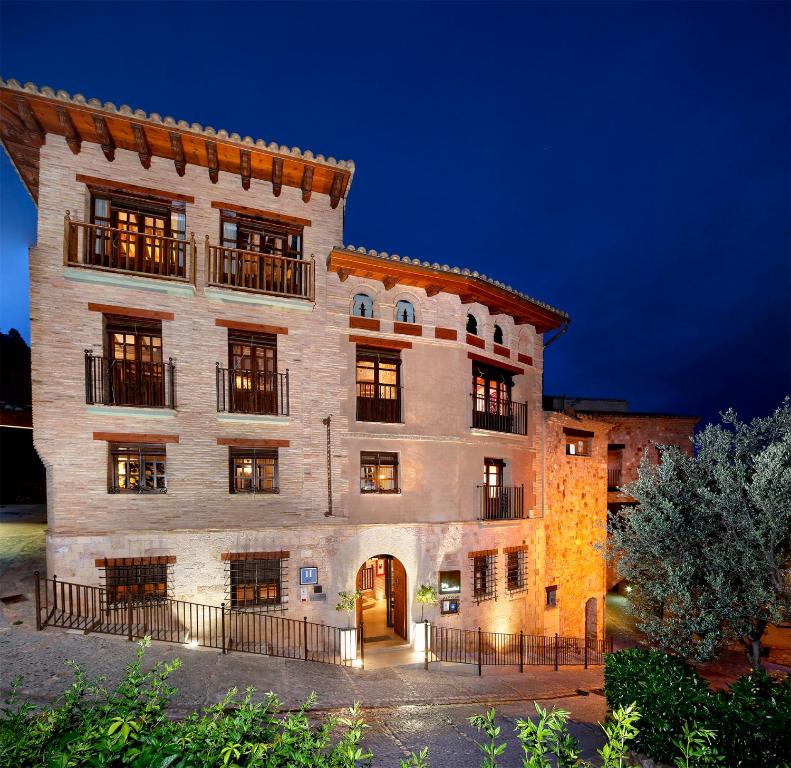 a large brick building at night with its lights on at Hotel Boutique Maribel (Adult Only) in Alquézar