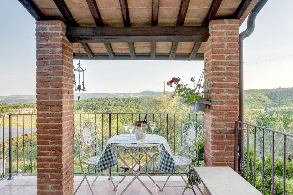 a patio with a table and chairs on a balcony at Il Fienile di Jenny in Sinalunga