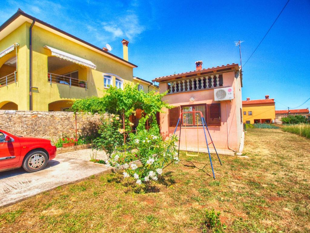 a house with a red car parked in front of it at Apartment Marcana 1382 in Marčana