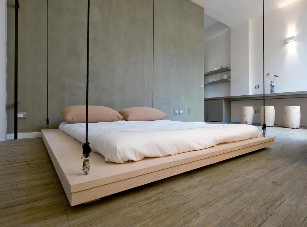 a bed with a swing in a room at Space is Luxury - Design House in Taormina