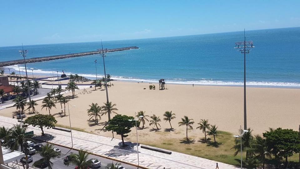 uma vista para uma praia com palmeiras e para o oceano em Apart-Hotel Terraços do Atlântico em Fortaleza