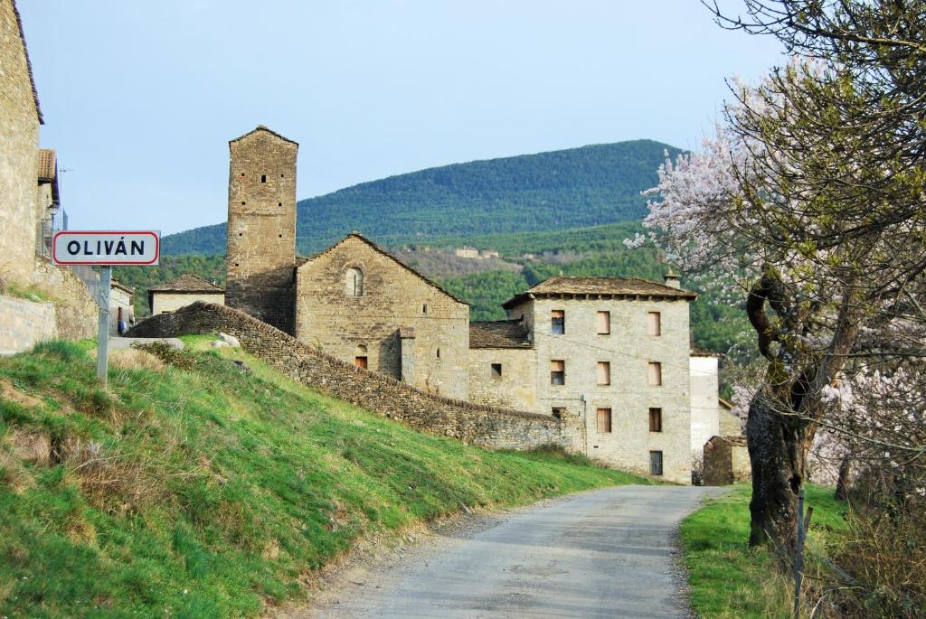 um sinal de rua em frente a um castelo numa colina em Casa Azon em Oliván