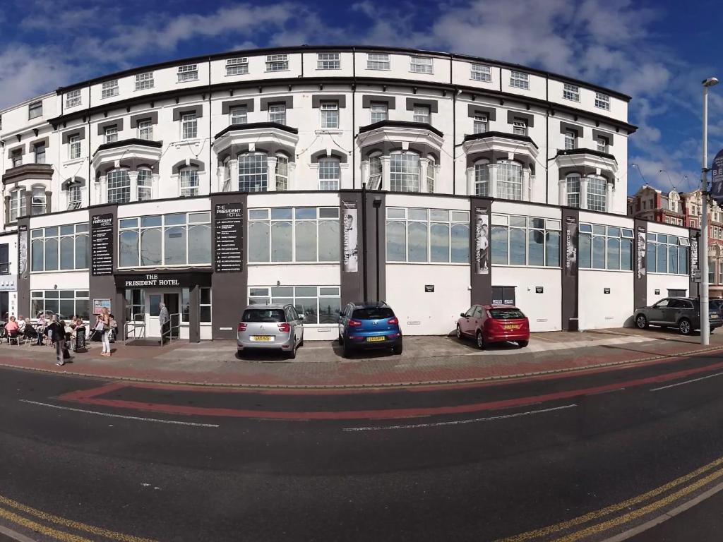 a white building with cars parked in front of it at The President Hotel in Blackpool