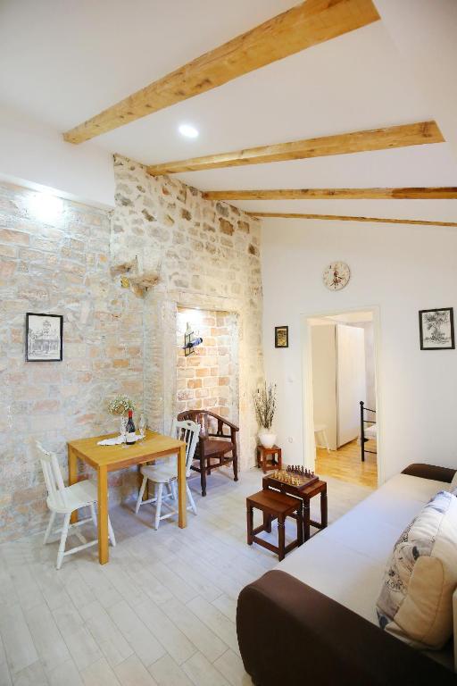 a bedroom with a table and a dining room at Apartments Grisogono in Zadar