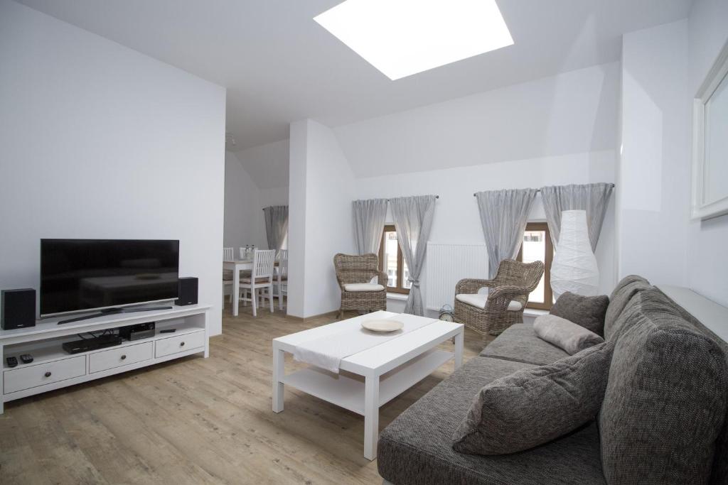 a living room with a couch and a tv and a table at Ferienwohnungen EULE in Lutherstadt Wittenberg