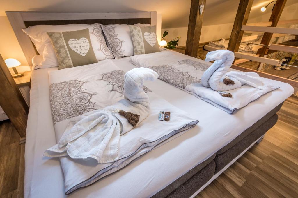 ノヴェー・ムニェスト・ナ・モラヴィエにあるLuxusní Apartmán NMNM Mezonetの白鳥2羽がベッドに座ってタオルを持っている