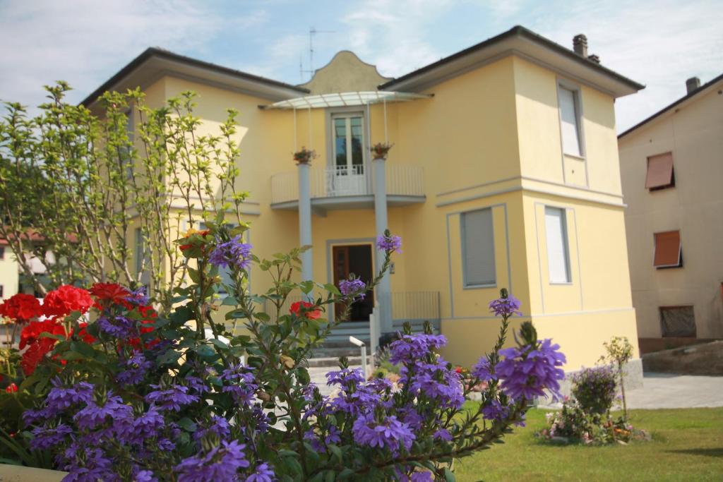 une maison jaune avec des fleurs devant elle dans l'établissement Affittacamere Bel Sole, à Borghetto di Vara