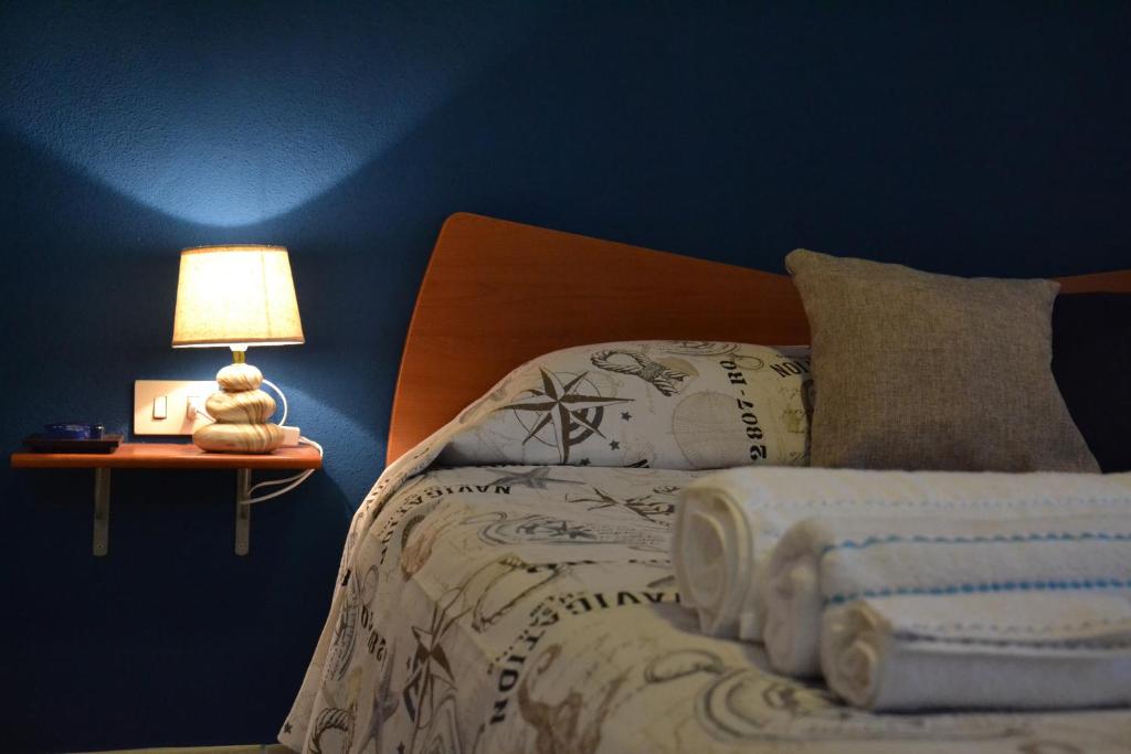 um quarto com uma cama com um candeeiro sobre uma mesa em Bed & Breakfast Gli Alisei em Siniscola