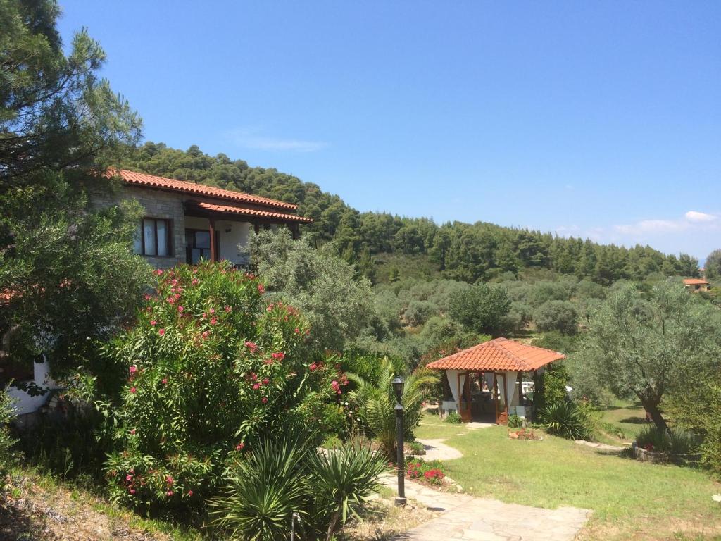 dom na wzgórzu z krzakami i drzewami w obiekcie Villa Rena w mieście Vourvourou