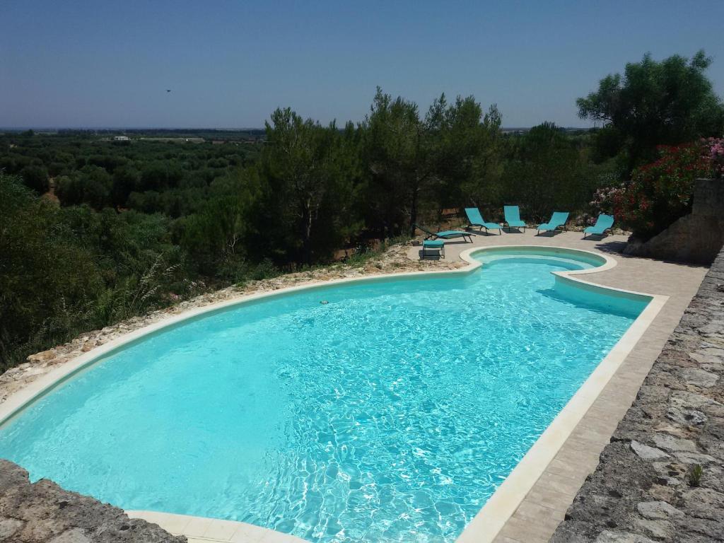 a swimming pool with chairs and a swimming pool at Masseria Le Terrazze di Serranova in Serranova