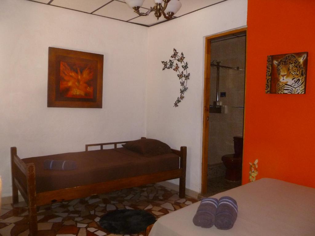 een slaapkamer met een bed in een kamer met oranje muren bij Hostel Wunderbar in Puerto Lindo