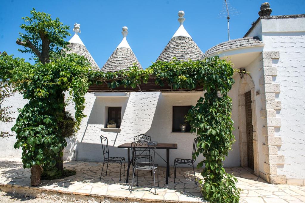 un patio con mesa y sillas frente a un edificio en Agriturismo Grotta Di Figazzano, en Cisternino